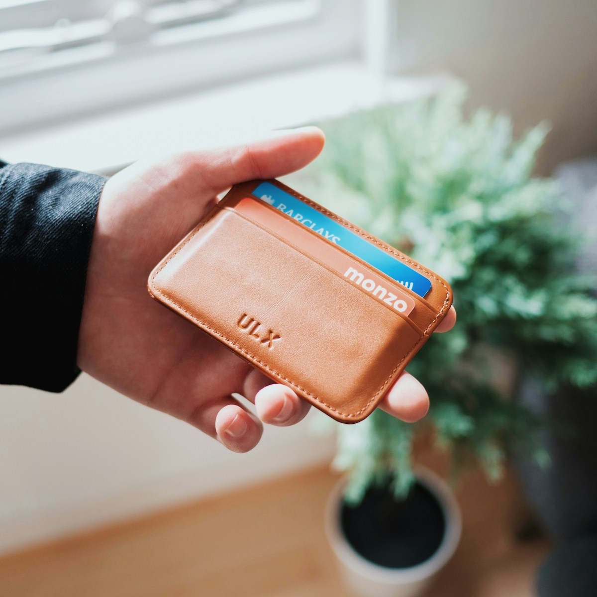 A photograph of a wallet holding a coral Monzo card.